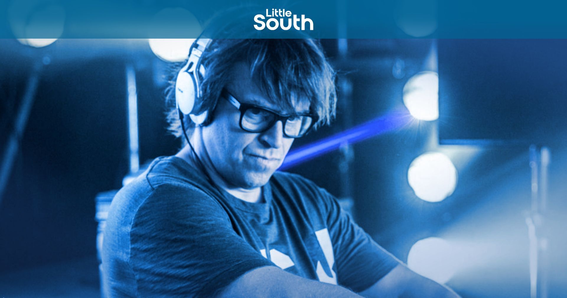 A man with a beard is pointing his finger at the camera.