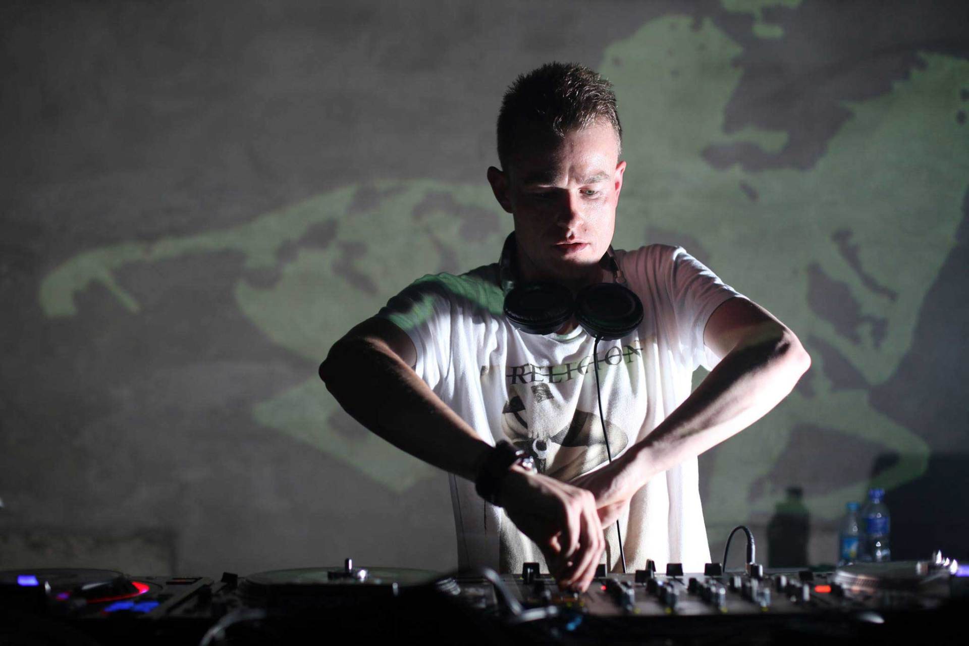 A man wearing headphones is playing music on a turntable.