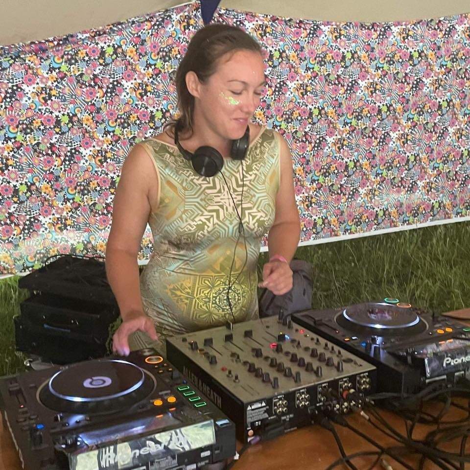 A woman is standing in front of a dj mixer.