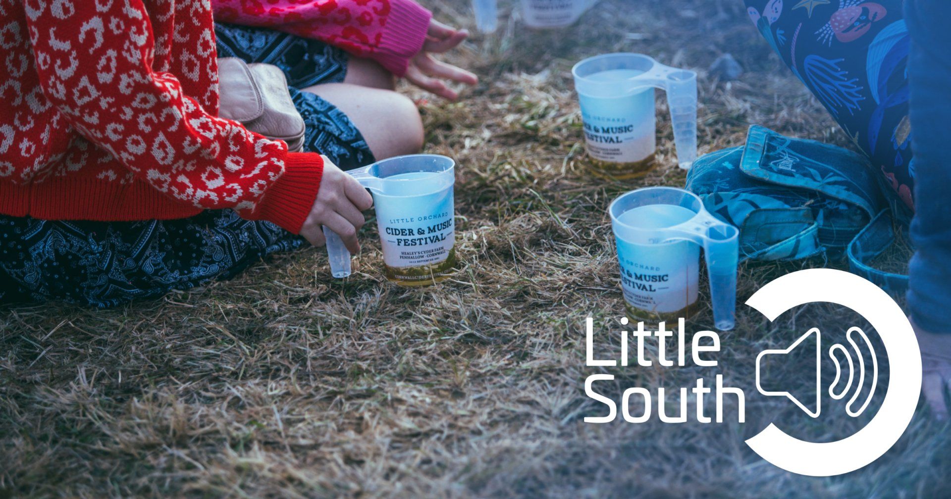 A group of children are sitting on the ground with measuring cups.