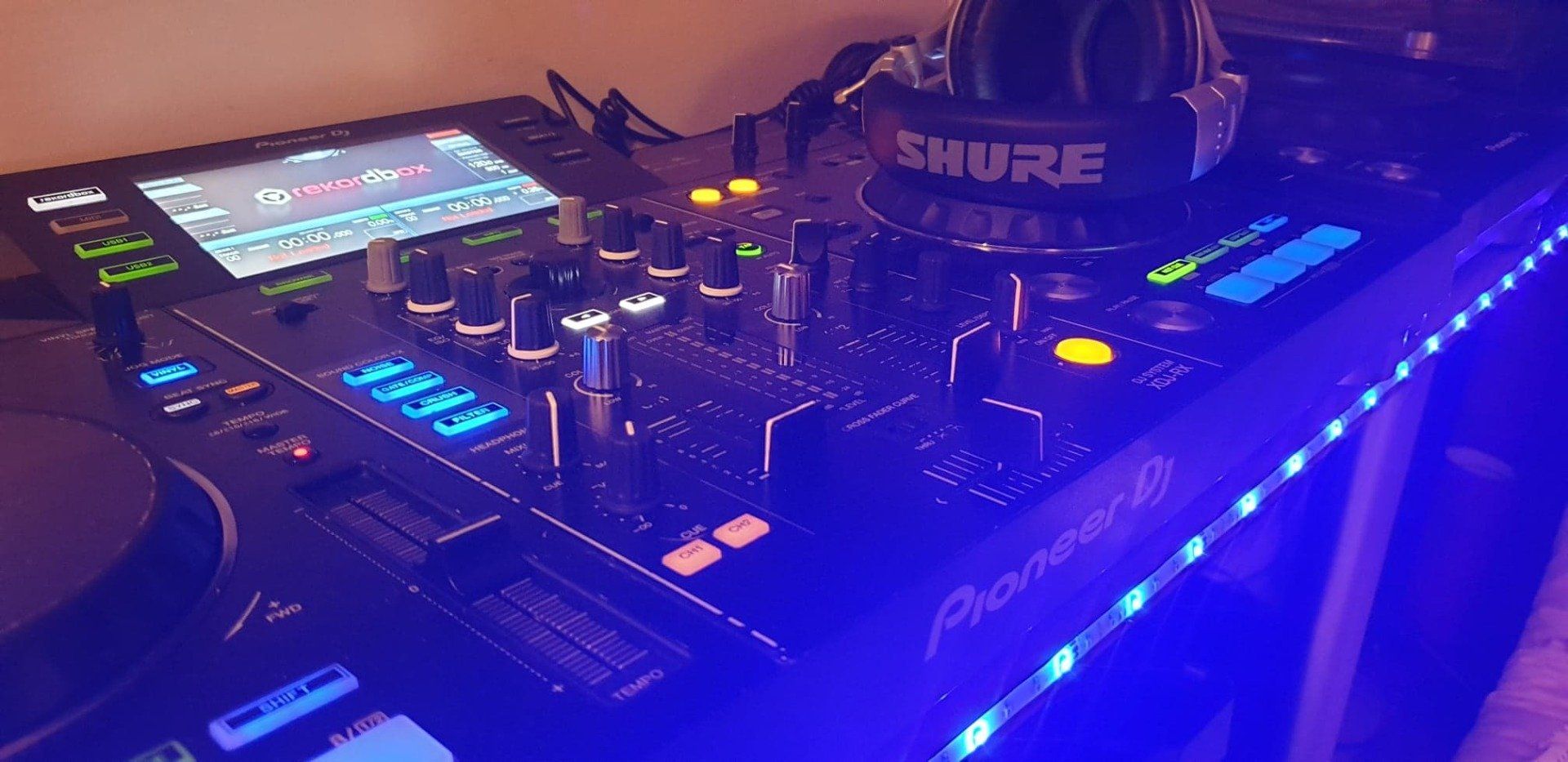 A dj mixer with headphones on top of it is sitting on a table.