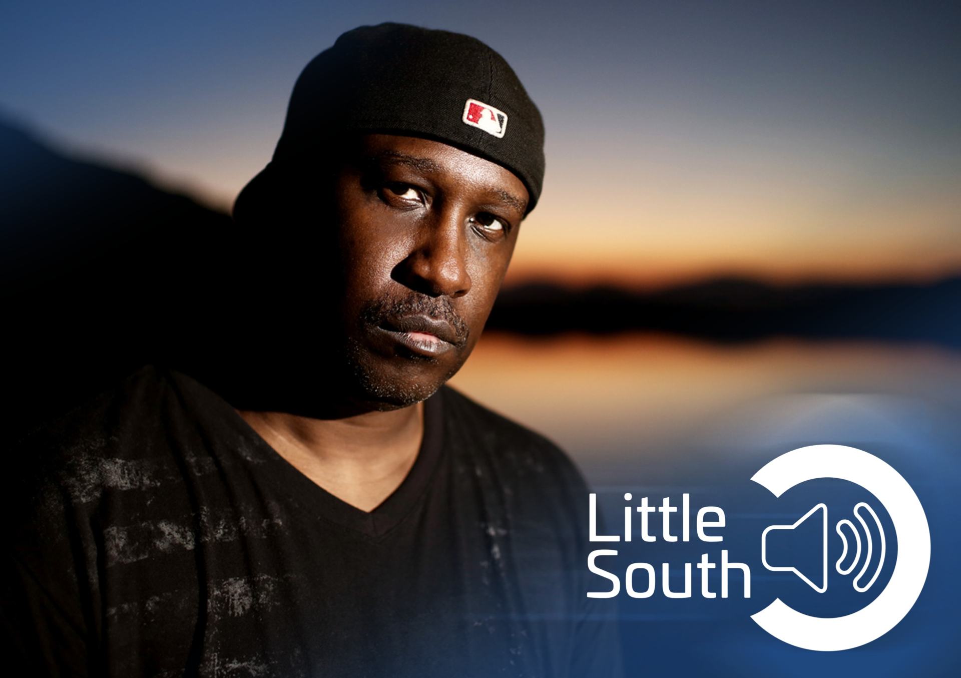 A man stands in front of a little south logo