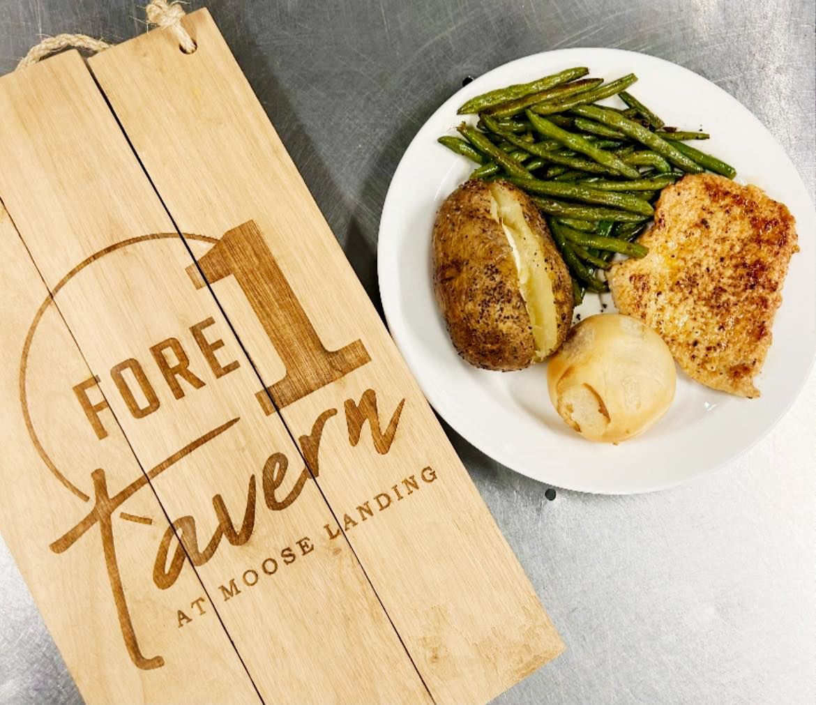 A plate of food next to a sign that says fore 1 tavern