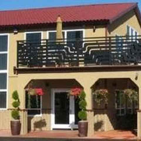 A large house with a balcony and a red roof.