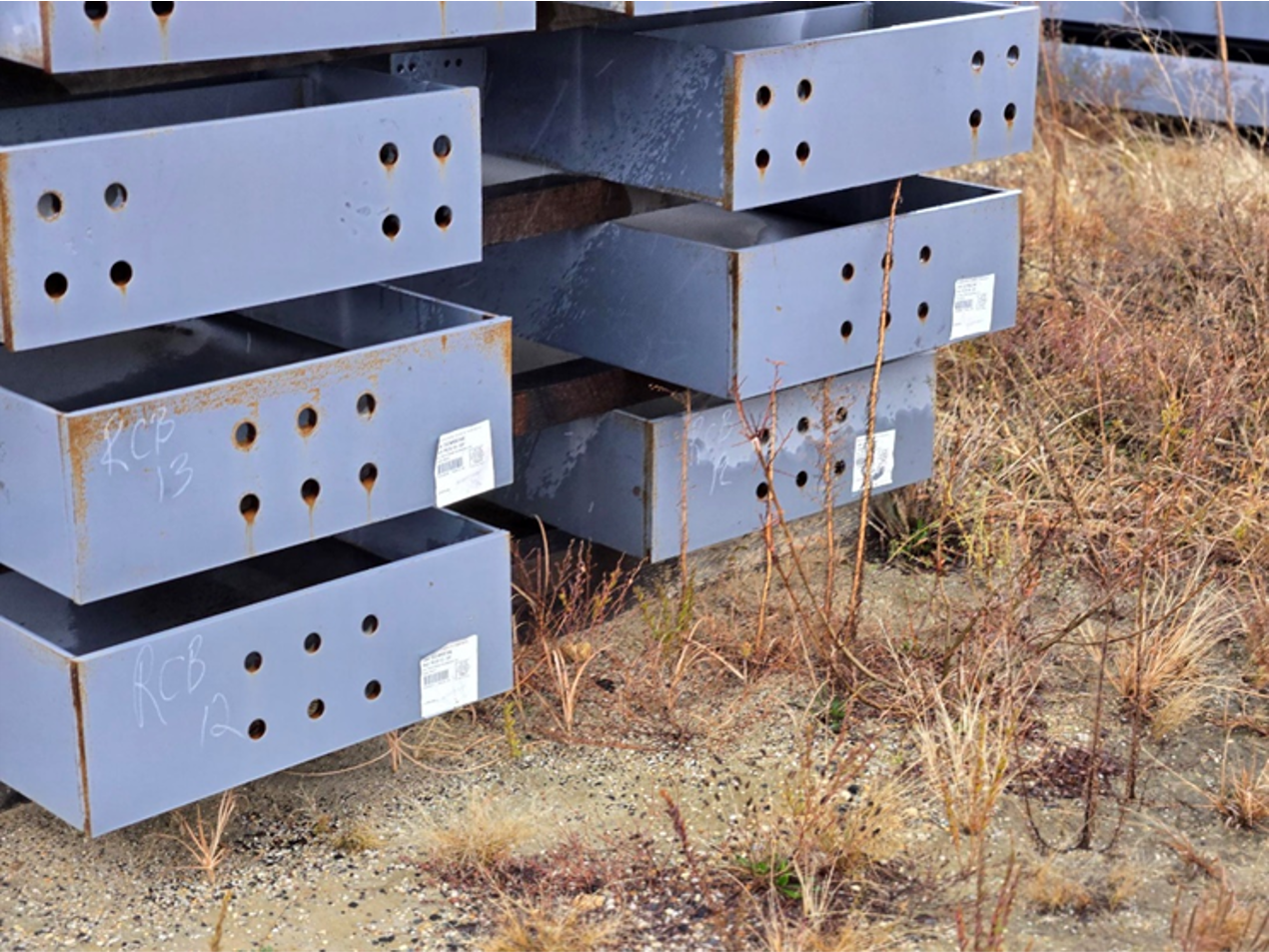 A stack of metal boxes sitting on top of each other in a field.