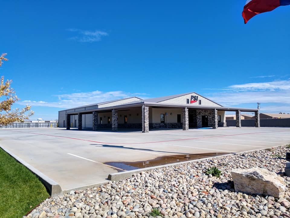 Large, light-colored building with stone columns under a bright blue sky. 