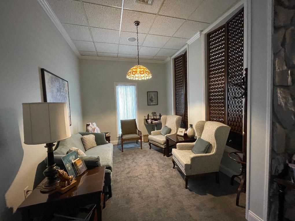 Cozy, well-lit waiting room with seating, decorative screen panels, and a hanging light fixture.