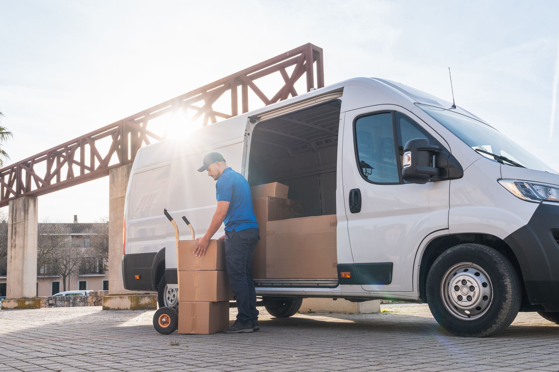 Worker unloading boxes from a delivery van at a construction site