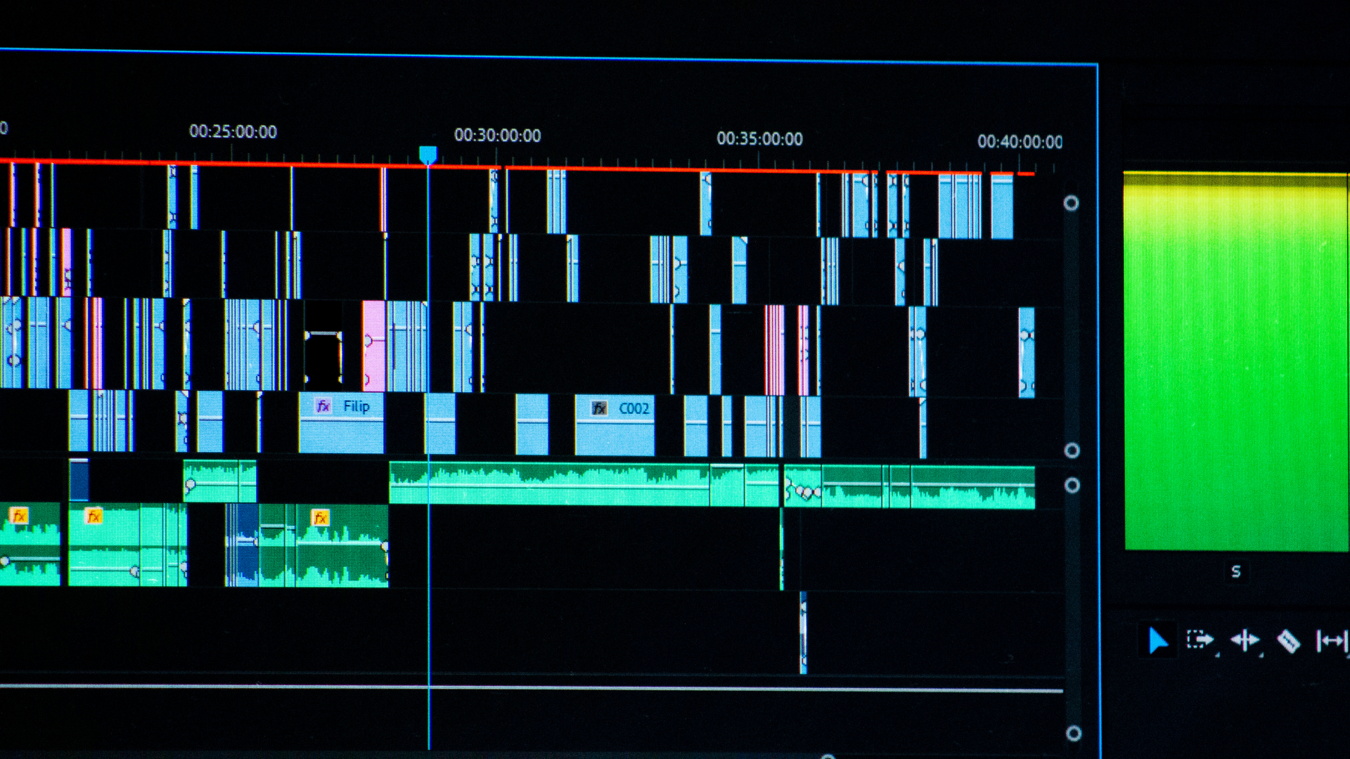 A video editing software timeline showing multiple tracks of audio and video clips alongside a green preview window.