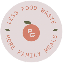 A circular logo on a soft pink background. An orange icon with two leaves sits above the letters 