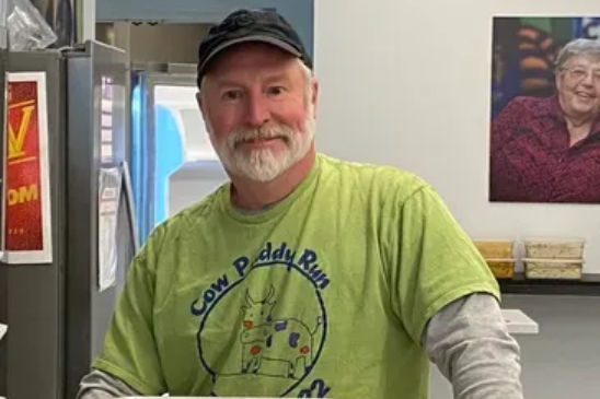 A smiling man wearing a lime green 