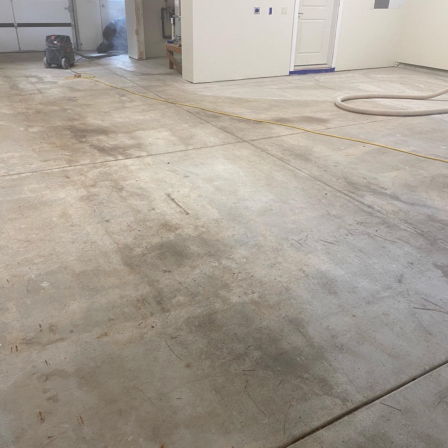 A concrete floor in a garage with a vacuum cleaner on it