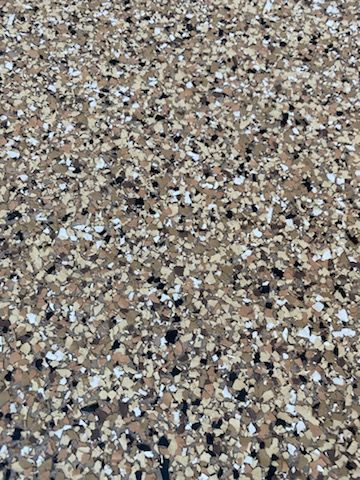 A close up of a concrete floor with a lot of small rocks on it.