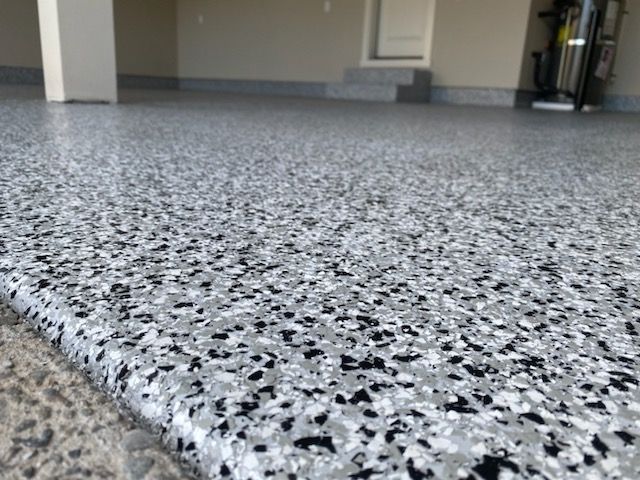 A close up of a gray and black floor in a garage.