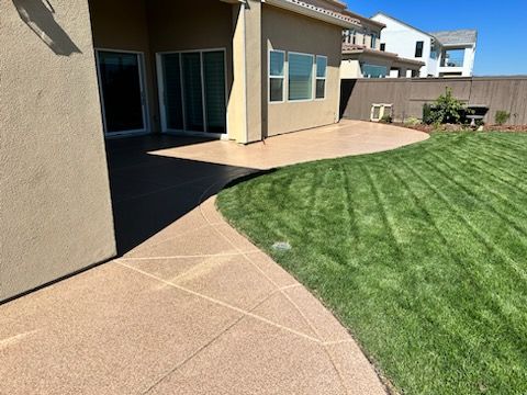 There is a patio in the backyard of a house.