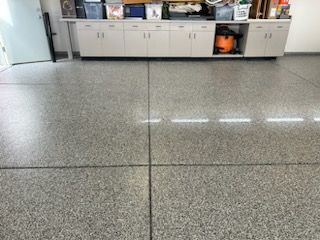 A large room with a concrete floor and cabinets.