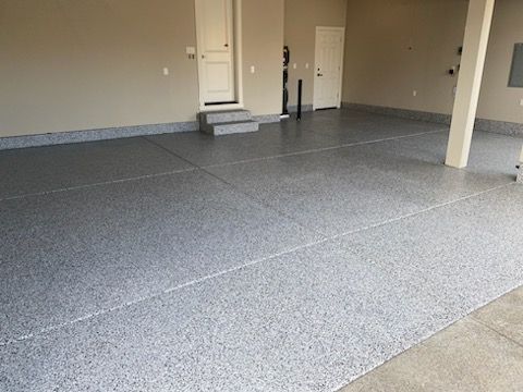 A garage with a gray floor and a door.