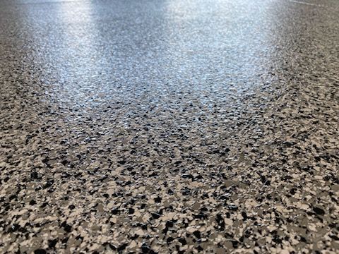 A close up of a gray and black marble floor.