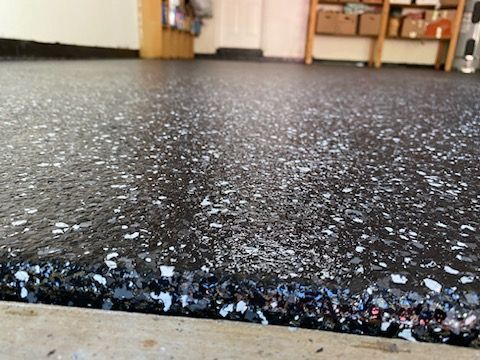 A close up of a black and white floor in a garage.