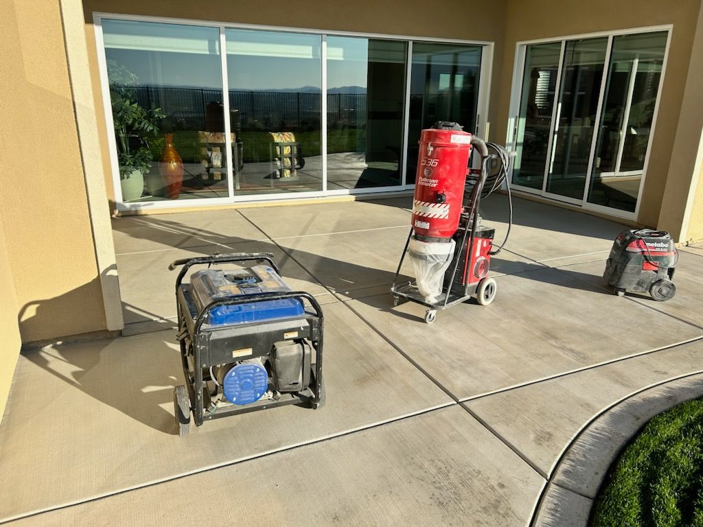 A generator and a vacuum cleaner are sitting on a patio in front of a building.