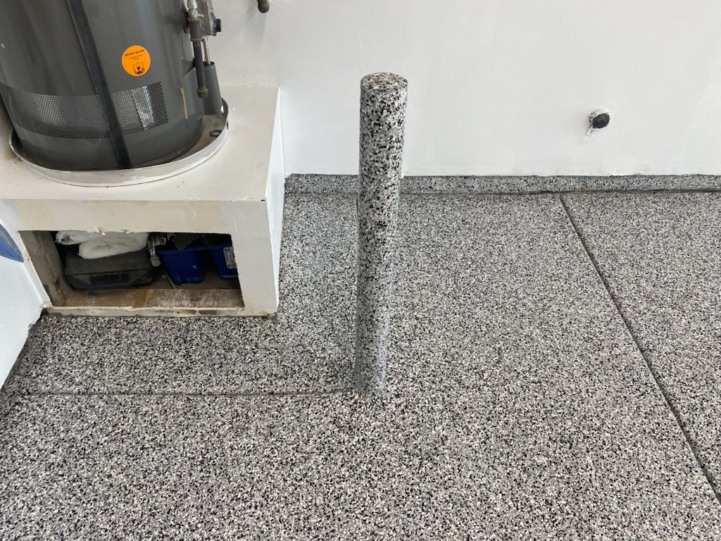 A vacuum cleaner is sitting on top of a concrete floor next to a pole.