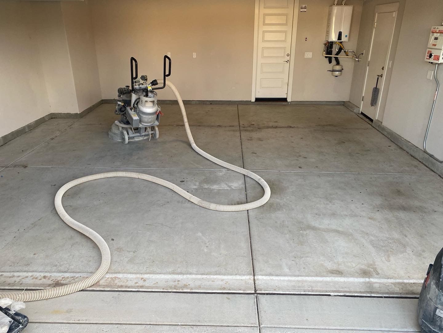 A hose is connected to a machine in a garage.