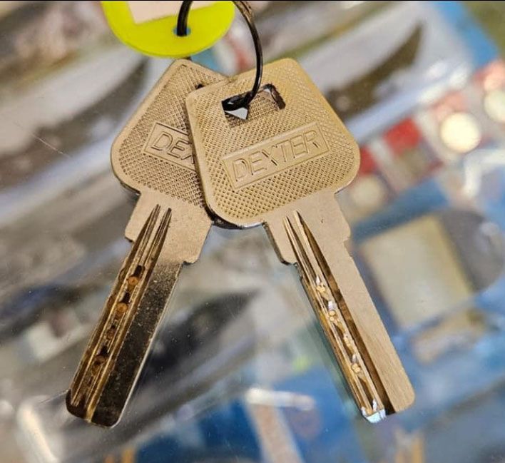 Un par de llaves Dexter colgando de una etiqueta amarilla.