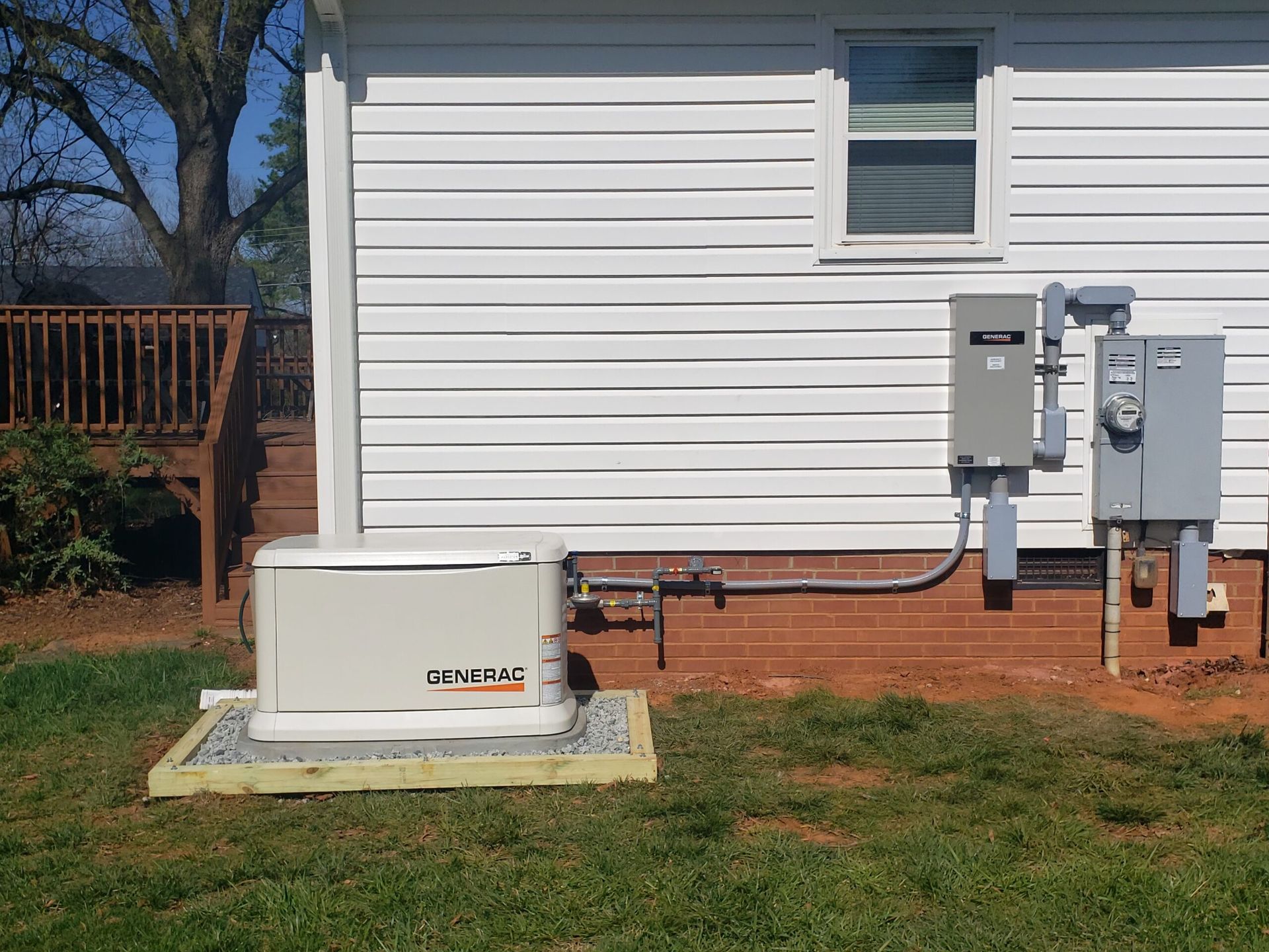 White outdoor electrical equipment and utility meters mounted beside a house with white siding.