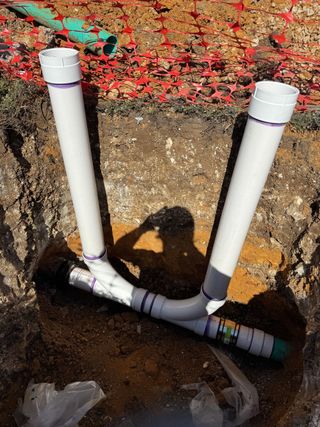 A plastic box filled with screws and wrenches on a wooden table.