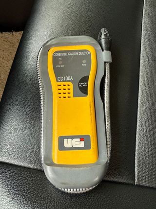 A plumber is fixing a sink pipe with a wrench.