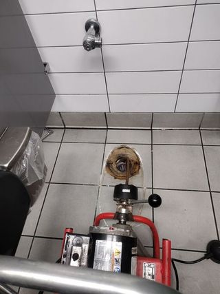 A plastic box filled with screws and wrenches on a wooden table.