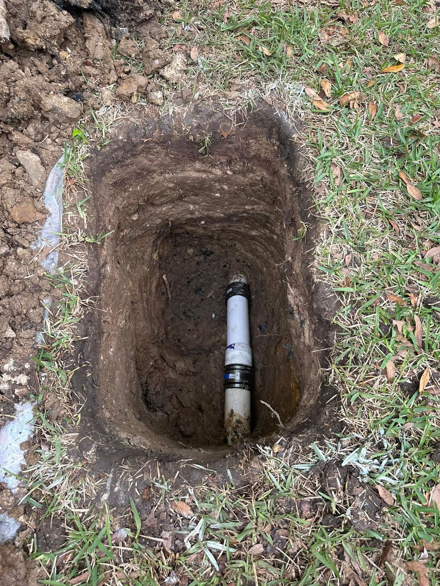 A hole in the ground with a pipe in it.