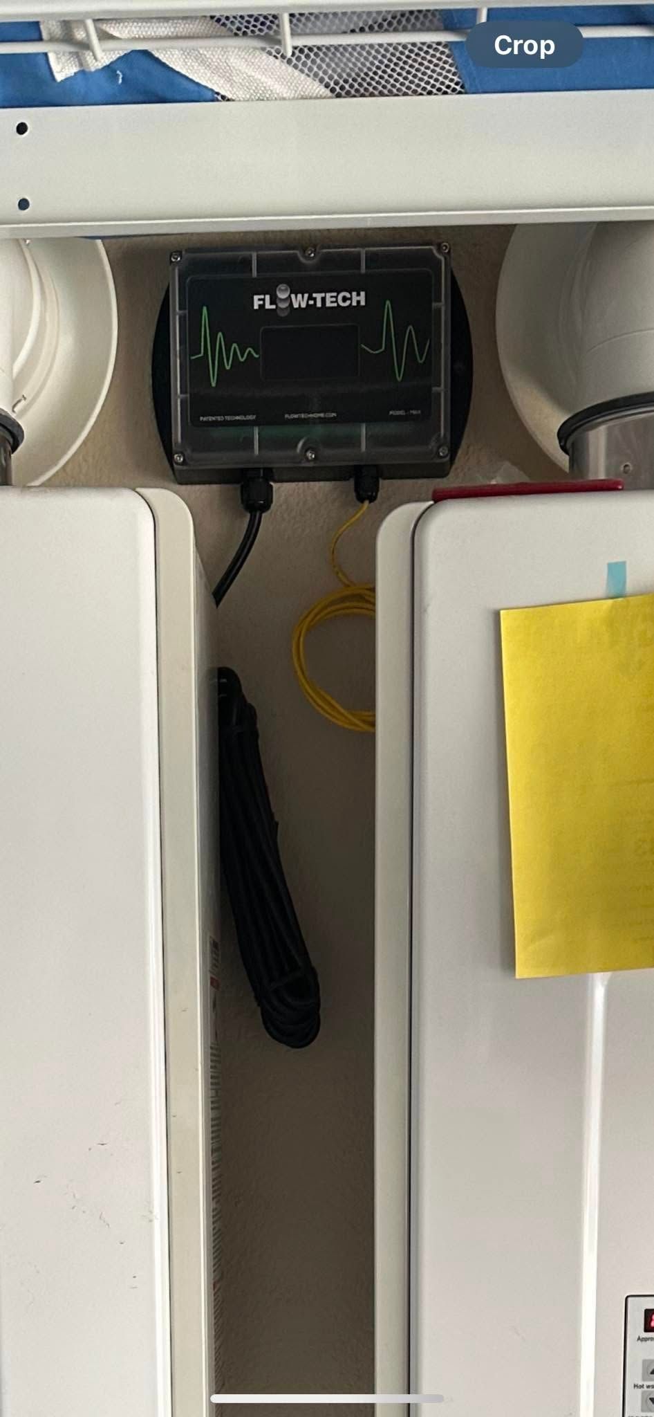A white refrigerator with a yellow note on the door.