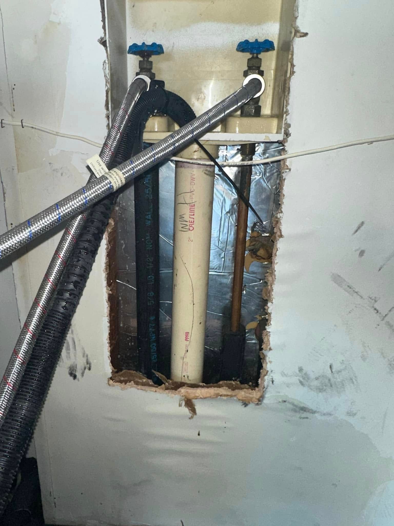 A hole in a wall with pipes coming out of it