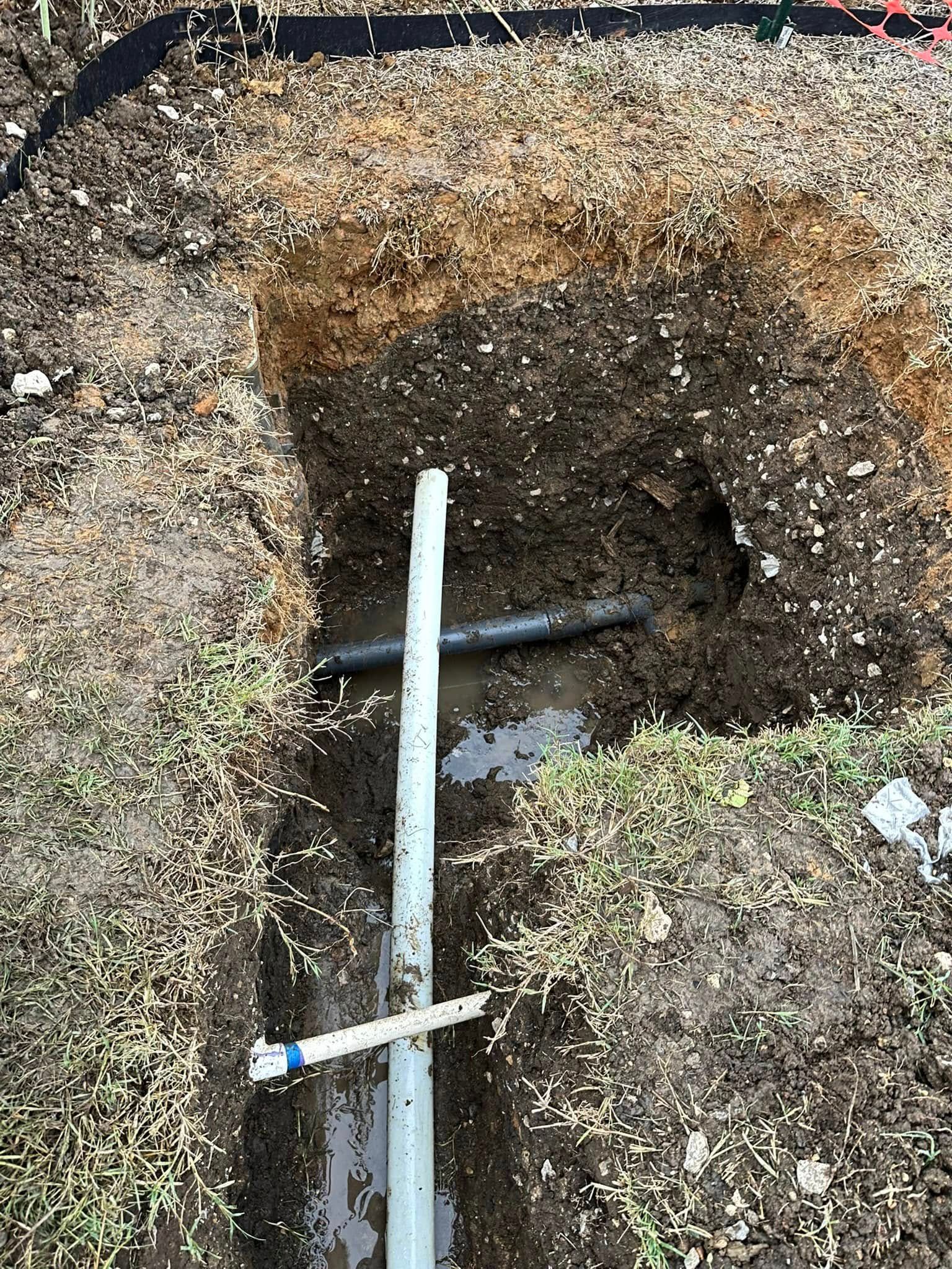 A pipe is sticking out of a hole in the ground.