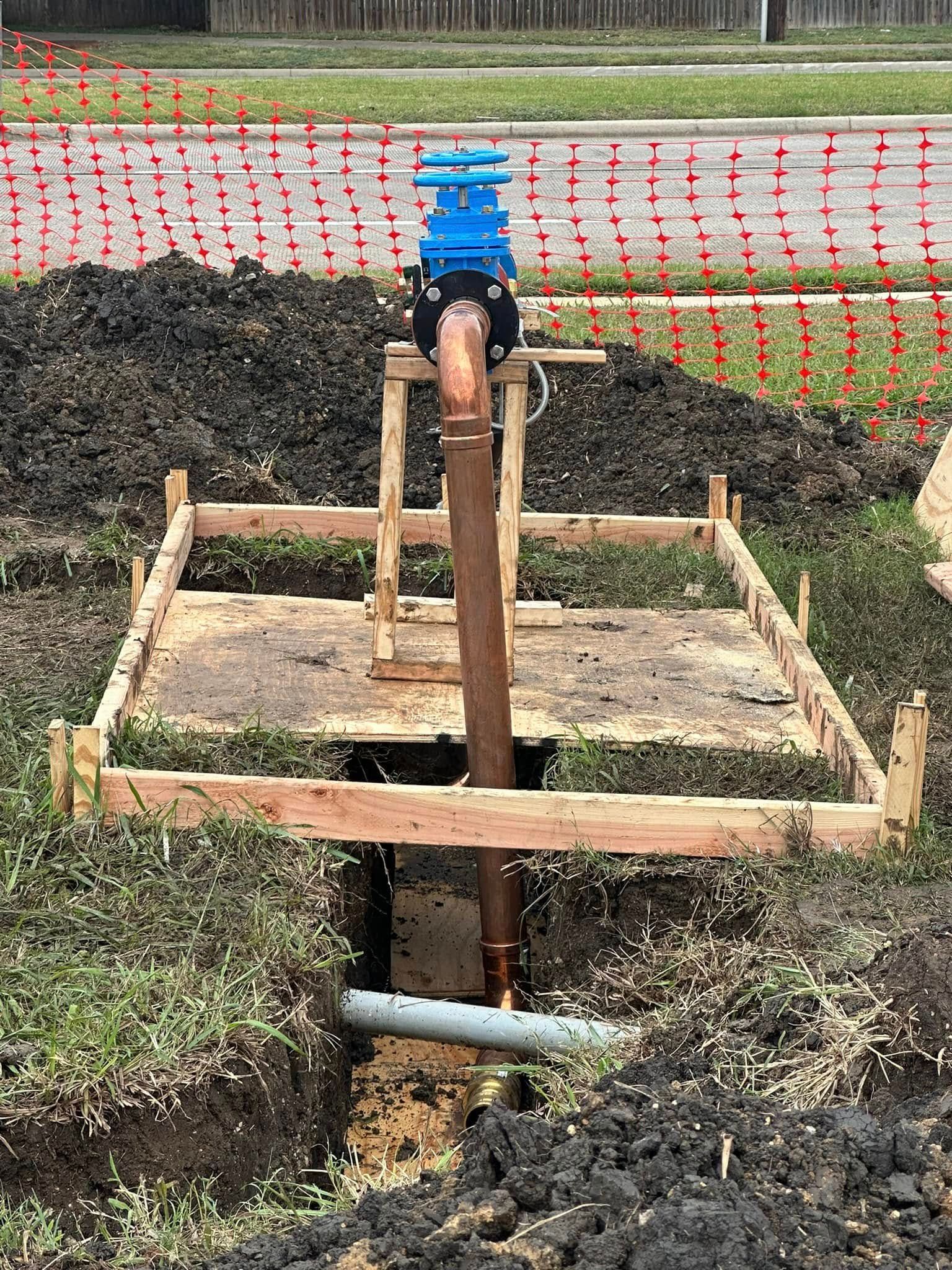 A water meter is sitting on top of a wooden platform in the dirt.
