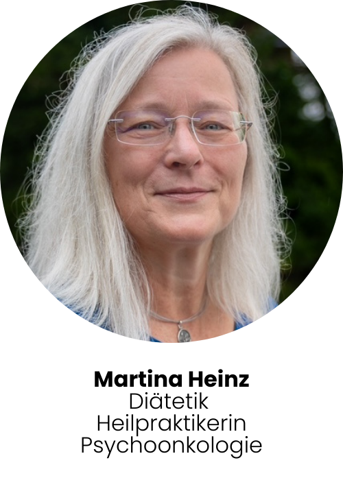 Foto: Martina Heinz, sie befindet sich in der Natur und lächelt in die Kamera. Martina trägt eine Brille und offene Haare