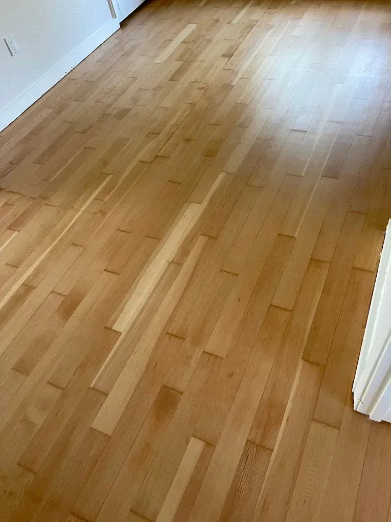 A close up of a wooden floor in a room.