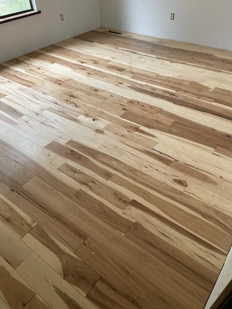 A room with a wooden floor and a window.