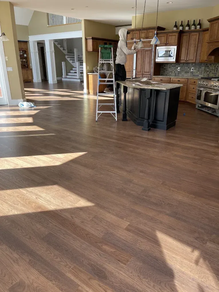 A man is standing on a ladder in a kitchen.