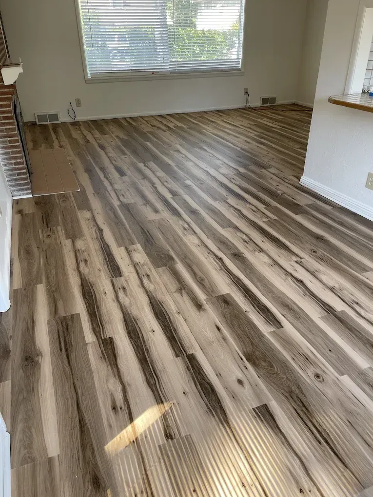 A living room with a wooden floor and a window.