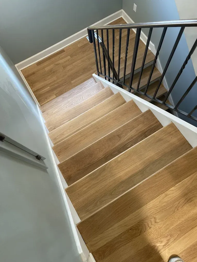 A wooden staircase with a metal railing in a house.