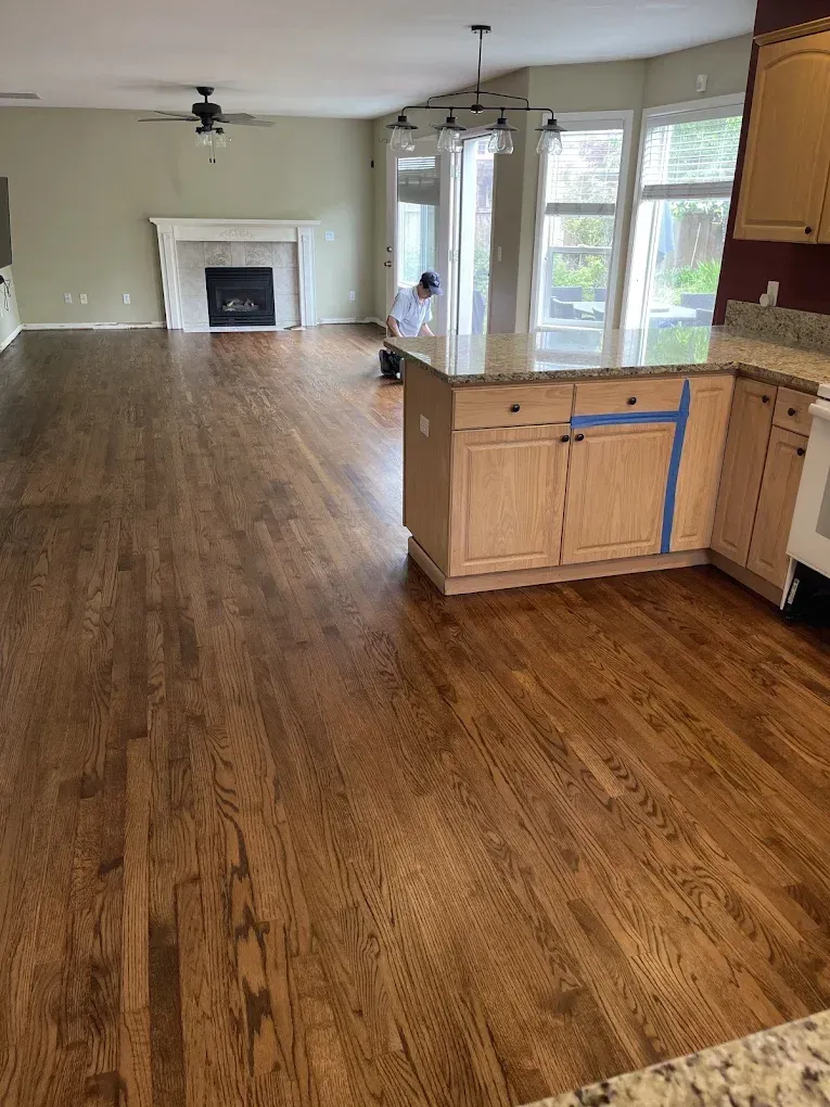 A kitchen with hardwood floors and a fireplace.