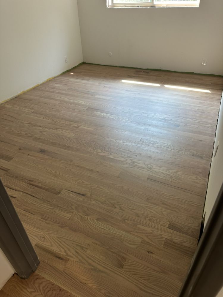 A room with a wooden floor and a window.