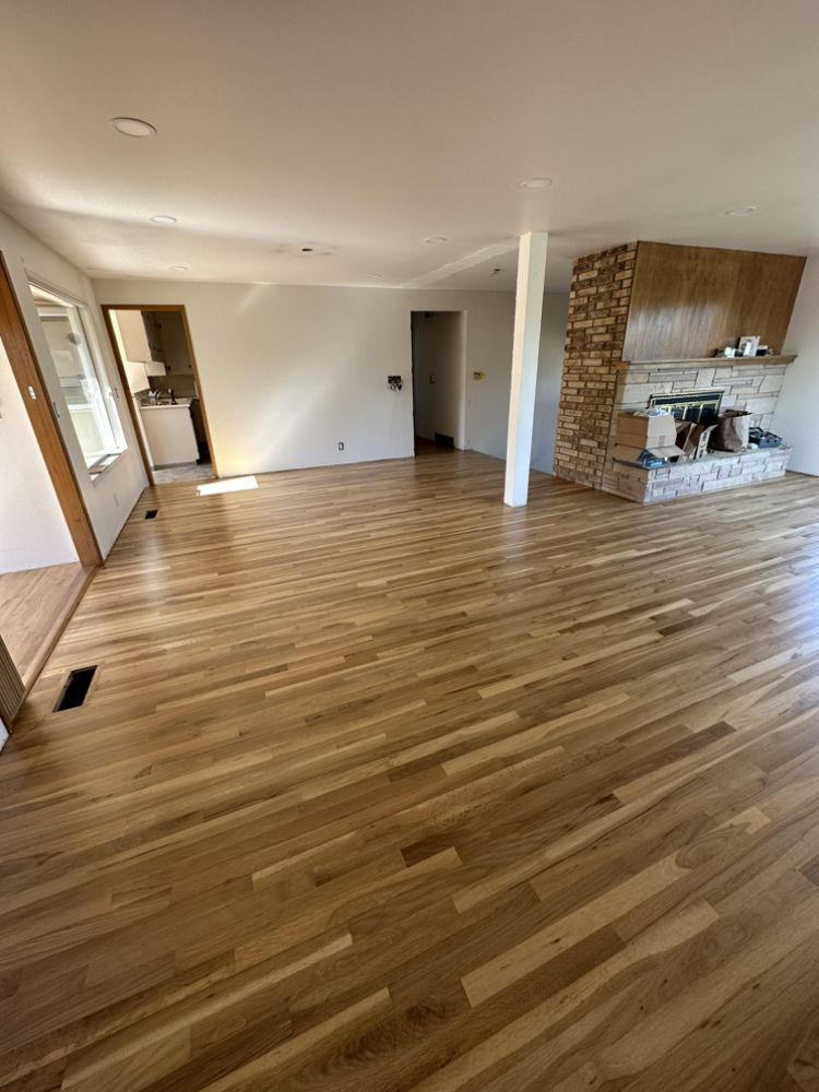 A living room with hardwood floors and a fireplace.