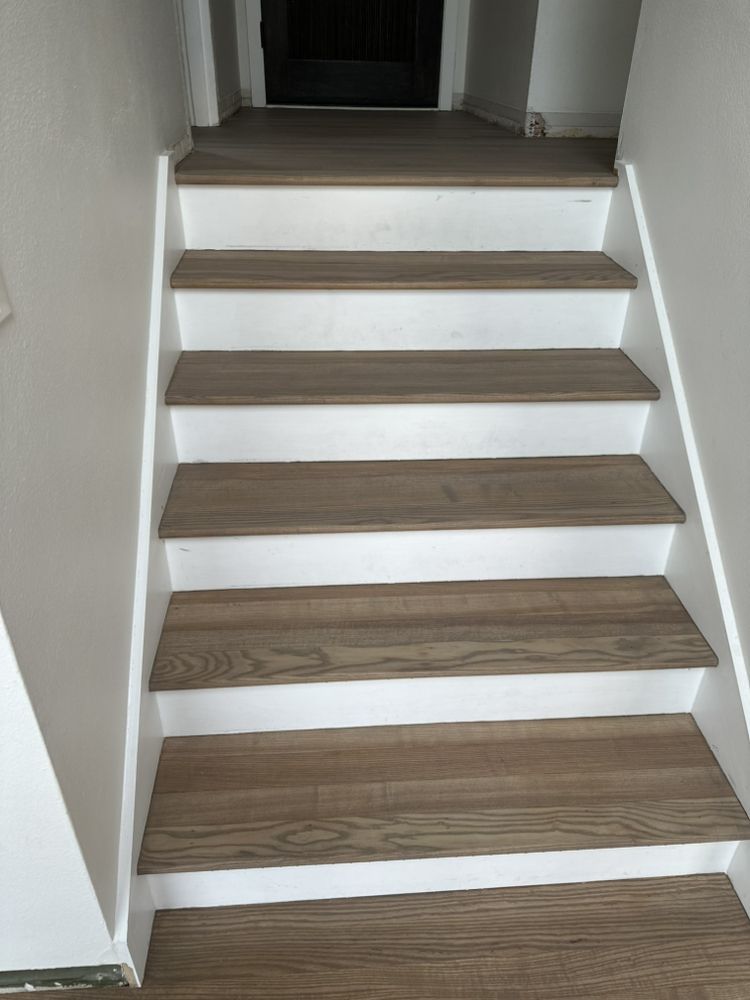 A set of stairs with wooden steps and white railings.