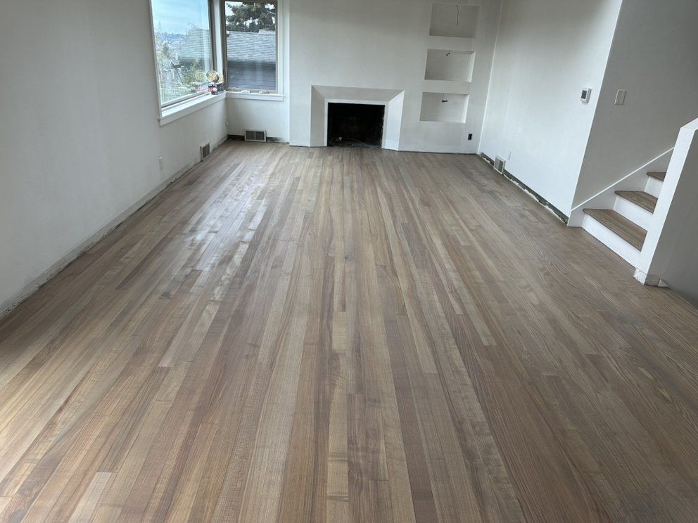A living room with hardwood floors and a fireplace.