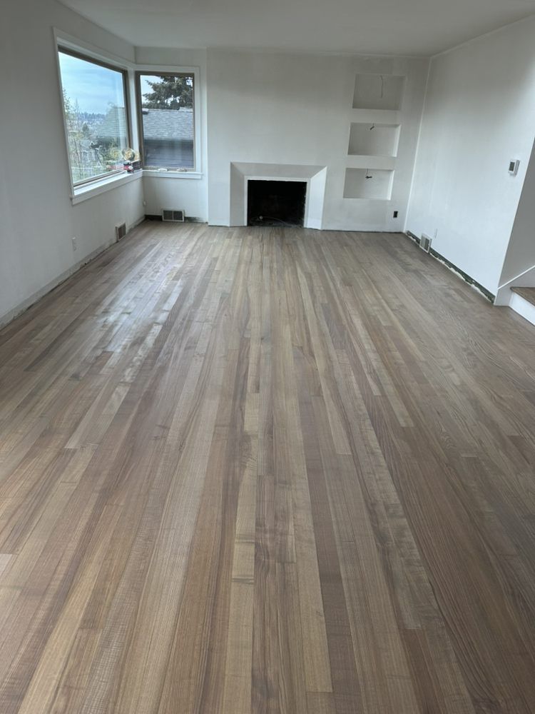 A living room with hardwood floors and a fireplace.