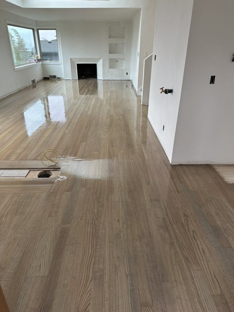 A living room with a wooden floor and a fireplace.
