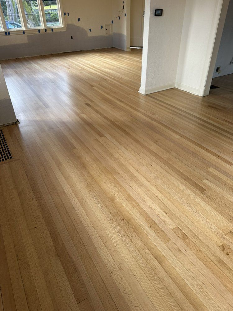 A living room with a wooden floor and white walls.